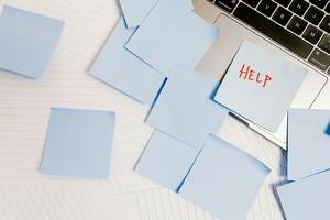 a laptop cover in sticky notes, one note says help